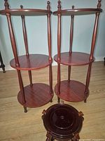 Two three-tier stands and one small round stand grouped together