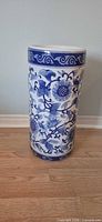 Front view of blue and white porcelain umbrella stand showing full pattern and shape