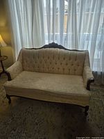 Front angled view of loveseat showing overall form, upholstery and wood trim