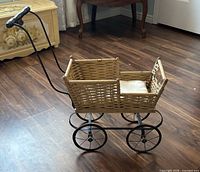 Full view of wicker pram with handle and wheels