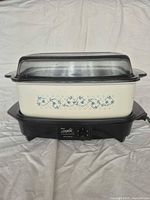 Full view of assembled slow cooker showing floral insert, lid, and base