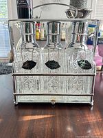 Front view of three decanters in chrome carrier