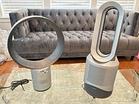 Both Dyson fans side by side on glass table