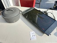Dutch oven with lid and induction hot plate on table