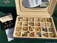 Overall view of jewelry storage case filled with brooches and separate cufflink set in box