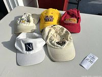 All five hats laid out showing fronts and overall wear