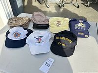 All seven hats laid out on table
