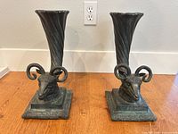 Front view showing both bronze cornucopia vases with ram heads and bases