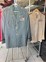 Both jackets hanging on rack showing overall condition and style