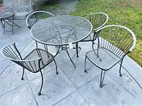overall view of round metal mesh patio table with four chairs