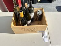 Overall view of Caymus wine crate with empty bottles and beer can