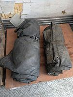 Two rolled black flatbed tarps on pallet