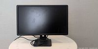 Front view of Dell monitor powered off on stand