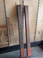 Front view of both steel fork extensions leaning on wall