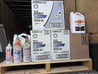 Overall view of pallet with three Shell Rotella oil cases, two jugs and three additive bottles