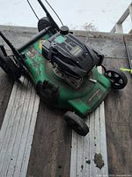 Full view of green Certified lawn mower showing deck, wheels, engine and handle