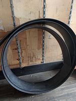 Full view of coiled black plastic roll standing vertically