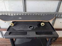 Full skateboard top view on cart showing grip tape and wheels