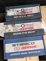 Three branded boxes: two Motor Wheel Crewson Automatic Brake Adjuster, one Stemco Crewson Automatic Brake Adjuster Kit