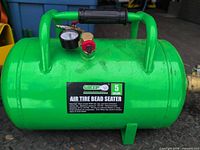 Side view of green Grip 5-gallon air tire bead seater tank showing label and handles