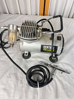 Compressor, hose, airbrush, filter visible overall