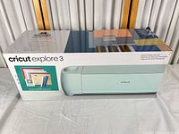 Front of Cricut Explore 3 retail box showing machine image and mint color