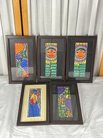 Group view of all five framed Mithila paintings on tabletop