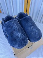 Pair of faux fur Nike Calm Mule SE shoes on box