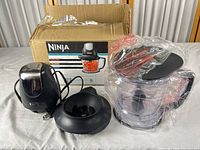 Overall view showing motor pod, collar base, pitcher with blade, lid, and box