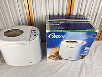 Bread maker beside original box, front view