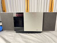 Front view of Panasonic SC-HC3 stereo showing silver centre panel and black speaker grilles