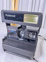 Front view of Polaroid OneStep Closeup 600 camera showing lens, flash and branding