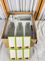 box with 4 glass bottles, labels sheet, purple marker visible