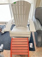 White Adirondack chair with orange footrest