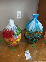 Two multicolor art glass vases on surface