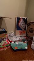 Stack of board game and puzzle boxes beside tabletop hockey components