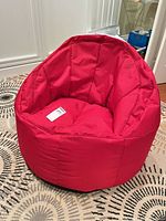 Front view of red bean bag chair on patterned rug