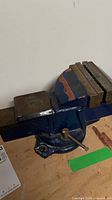 Overall view of blue swivel bench vise mounted on work surface