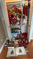 Overview of lot in closet showing stockings, throws, ornament boxes, placemats and additional décor