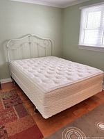 Overall view of bed showing mattress, box spring, headboard, frame
