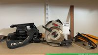 Shelf view of all three corded power tools: Craftsman belt sander, Craftsman circular saw, Canadian Tire jig saw