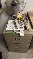 overall lot view showing filing cabinet with items on top