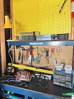 Overview of pegboard with hanging tools, level, tool belt, organizer