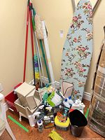 Full lot showing ironing board, mops, storage bins, cleaning liquids