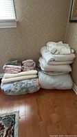 Stack of comforters, sheets and mattress pad