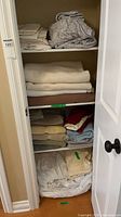 Overview of folded linens and towels on closet shelves
