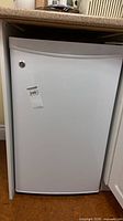 Front view of GE compact fridge under counter