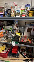 Shelf with assorted adhesives, cleaners, light bulbs, hardware, metal funnel, bit set, paint supplies