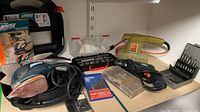 Overall view of Mouse sander, belt sander, drill, bit sets on shelf