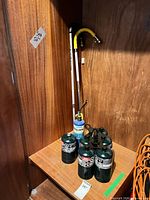 Overall view showing six green Coleman cylinders, blue cylinder with torch, two weed burner wands